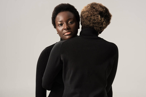 belles femmes afro-américaines à col roulé noir câlins isolés sur gris
 - Photo, image