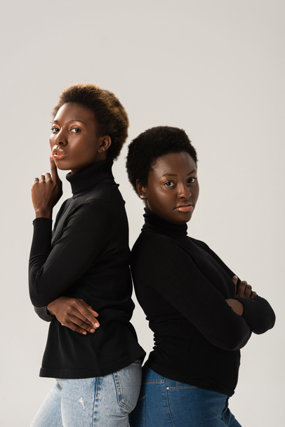 confident african american friends in black turtlenecks standing back to back isolated on grey - Foto, immagini