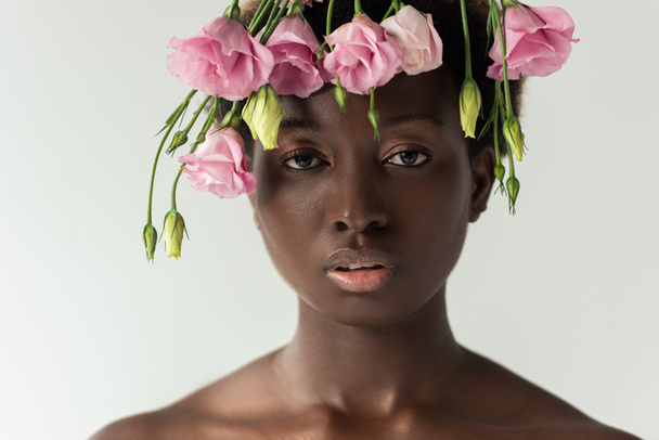 attractive naked african american woman with pink eustoma flowers isolated on grey - Photo, Image