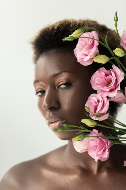 attractive naked african american girl with pink eustoma flowers isolated on grey - 写真・画像