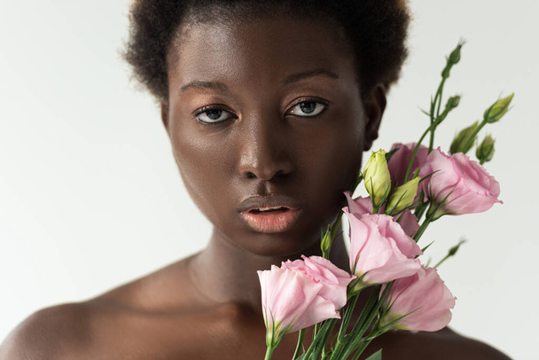 naked african american girl with pink eustoma flowers isolated on white - Photo, Image