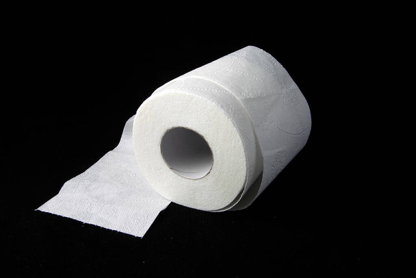 Tres rollos de papel higiénico sobre fondo negro
 - Foto, Imagen