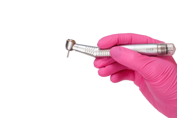 Dentist's hand in a latex glove with new high-speed dental handpiece on white isolated background. Medical tools concept. - Photo, Image