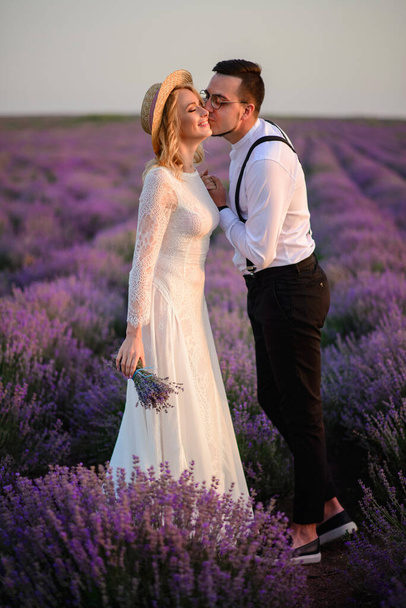 Young newlyweds in blooming lavender. - Фото, изображение