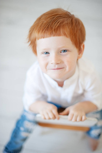 Funny red-haired boy in a white shirt - Фото, изображение