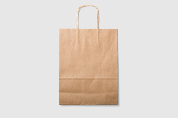 Mockup of a blank kraft paper shopping bag with handles on light grey background. High resolution. - Photo, Image