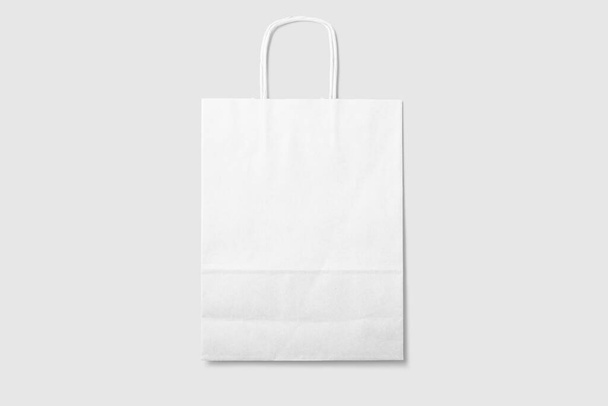 Burla de una bolsa de compras de papel blanco en blanco con asas sobre fondo gris claro. Alta resolución
. - Foto, imagen