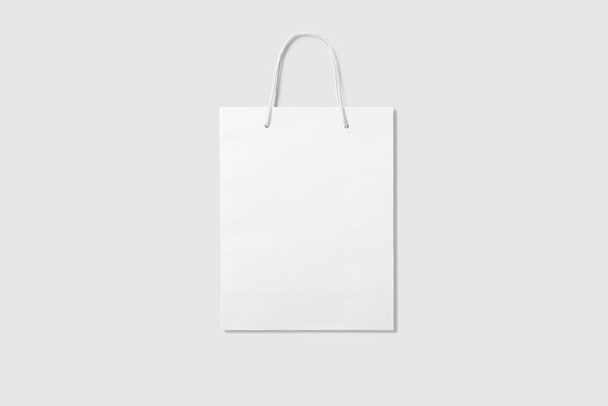 Burla de una bolsa de compras de papel blanco en blanco con asas sobre fondo gris claro. Alta resolución
. - Foto, Imagen