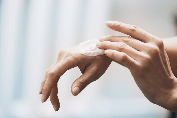 Woman applying moisturizing cream on hands - Photo, Image