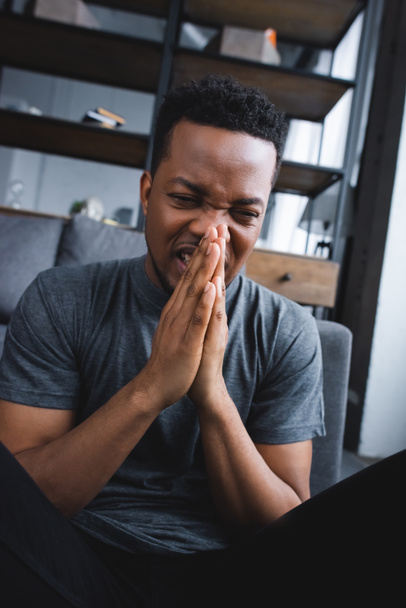 stressed african american man suffering from panic attack with hands together at home - Photo, Image