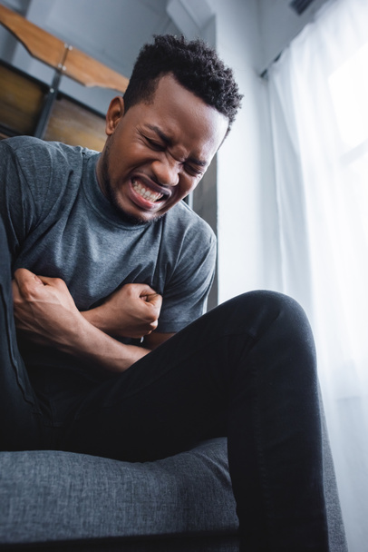 stressed african american man suffering from panic attack at home - Fotó, kép