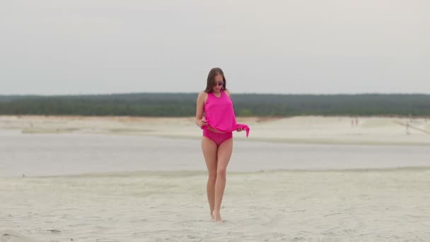 Kuuma nainen nauttivasti kävely varpaillaan hiekassa
 - Materiaali, video