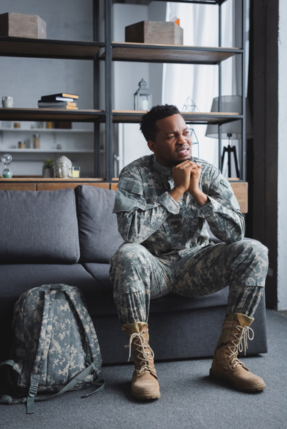 trieste Afrikaans-Amerikaanse soldaat in militair uniform lijdt aan PTSS thuis - Foto, afbeelding