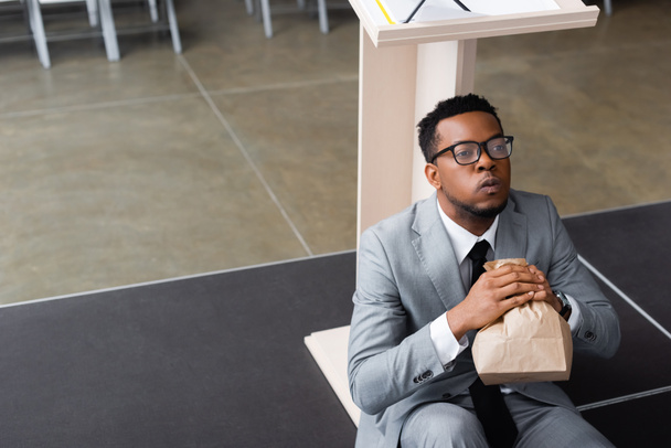 νευρικό αφροαμερικανός ομιλητής κρατώντας χάρτινη σακούλα και έχοντας κρίση πανικού πριν από την επιχειρηματική διάσκεψη  - Φωτογραφία, εικόνα