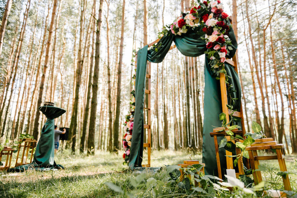 Koristelu kukka-asetelma seremoniallinen kaari nuoripari häät seremonia vihreässä metsässä
 - Valokuva, kuva