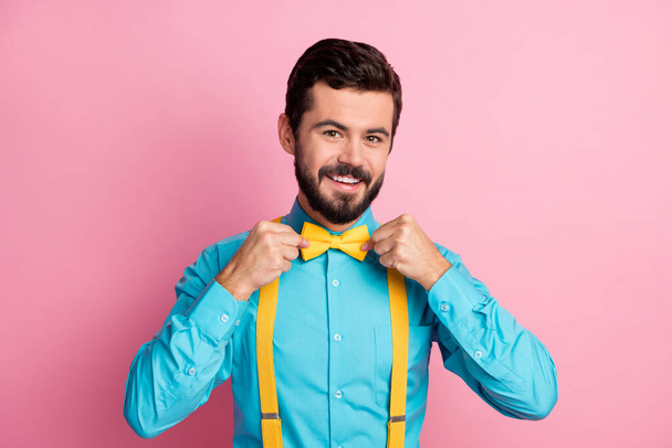 Close-up portrait of his he nice attractive cheerful cheery content imposing well-dressed bearded guy wearing festal mint blue shirt fixing bow-tie isolated over pastel pink color background - Фото, изображение