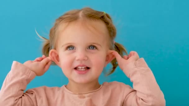Beautiful little girl in studio points her ears - Materiał filmowy, wideo