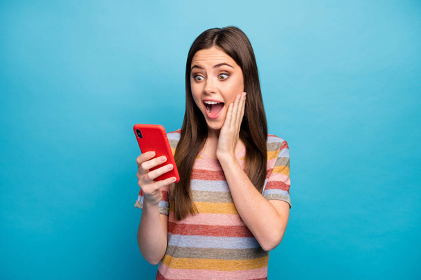 Close-up portrait of her she nice lovely pretty cute winsome charming amazed cheerful cheery girl using app service online shopping isolated over bright vivid shine vibrant blue color background - 写真・画像