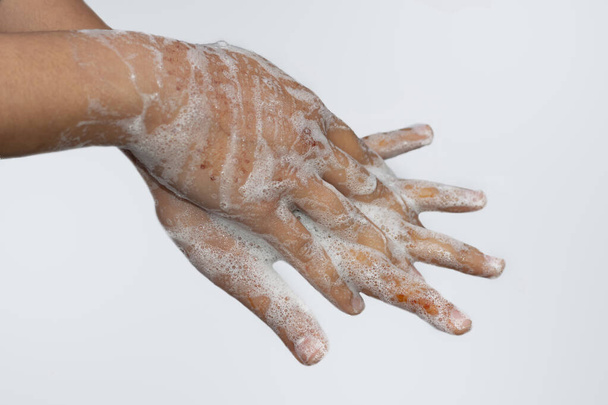  Une fille asiatique se lave les mains avec du savon isolé avec un fond blanc. Concept d'hygiène.Prévenir le virus de la couronne (covid-19). Concentration sélective
. - Photo, image