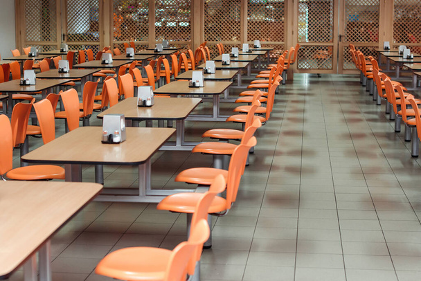 Kávézó vagy ebédlő belseje. Iskolai büfé. Gyári étkezde székekkel és asztalokkal, senki. Modern büfé belső tér. Tiszta kantin a modern iskolában. Ebédlő. - Fotó, kép