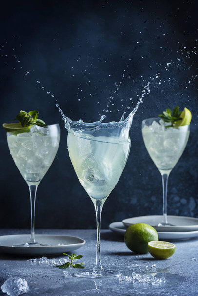 Splash of mojito cocktail with rum, ice, lime and mint, selective focus image - 写真・画像