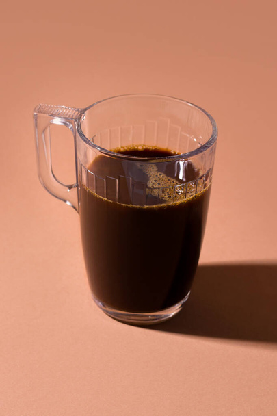 cup with black coffee on a brown background - Photo, Image