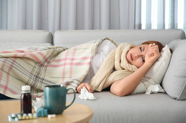 Sick woman lying on sofa at home. Influenza virus - Фото, зображення