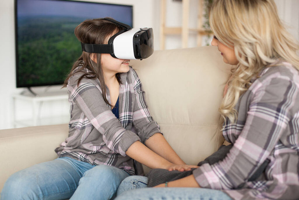 Menina feliz desfrutando de seu fone de ouvido realidade virtual
 - Foto, Imagem