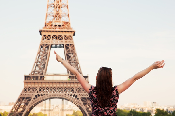 Jovem mulher feliz de frente para a Torre Eiffel, Paris, França
 - Foto, Imagem