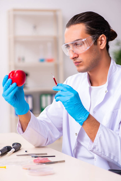 Νεαρός ειδικός στη διατροφή των αρρένων δοκιμάζει τρόφιμα στο εργαστήριο - Φωτογραφία, εικόνα