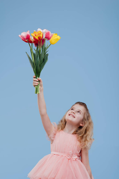 Happy girl raising hands with bouquet of flowers - Fotoğraf, Görsel