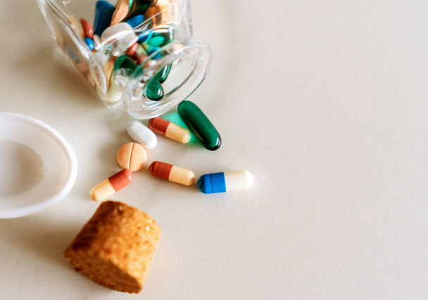 Bovenaanzicht van medicijnen tabletten giet uit pillen fles van marmer textuur witte achtergrond. Gezondheidszorg medische levensstijl trendconcept. - Foto, afbeelding