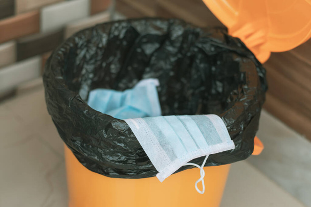 Covid-19, 2019-nCov o Coronavirus consigliano di gettare o smaltire la maschera medica nel cestino chiuso o nella spazzatura correttamente dopo l'uso - concetto che dimostra di fare pratica igienica
. - Foto, immagini