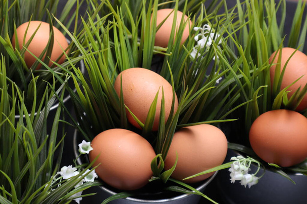 Huevos de Pascua entre hierba sobre fondo negro texturizado
. - Foto, imagen