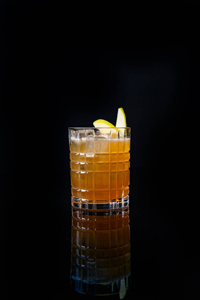 glass with drink and ice cubes on a black background, copy space - Foto, imagen