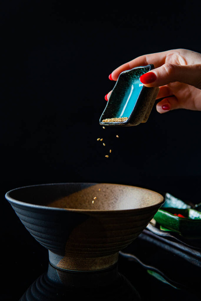 cropped shot of woman adding ingredients into bowl while cooking meal - Fotó, kép