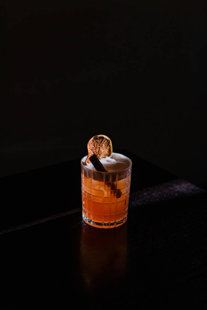alcoholic cocktail in a glass with ice cubes on black background - 写真・画像