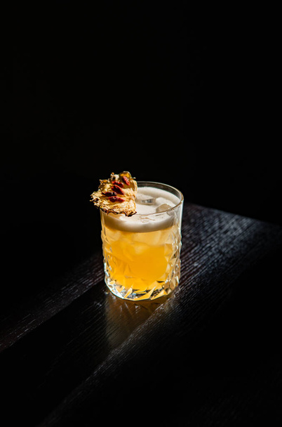 tequila-white cocktail with lemon and ice on black background - 写真・画像