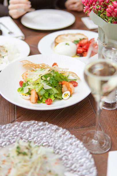close up of plate of salad with shrimps, eggs and vegetables on table in restaurant - Foto, Imagem