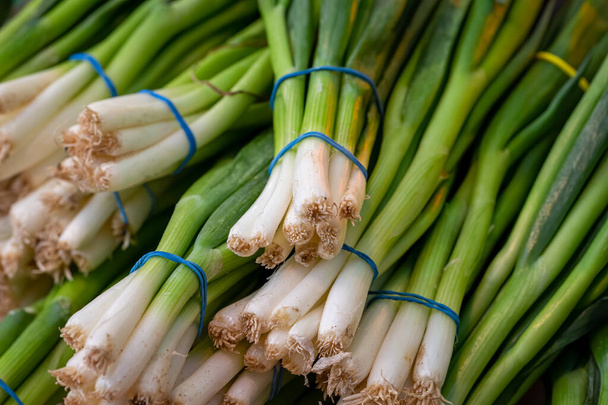 Green spring onions on sale on a market stall - Photo, Image