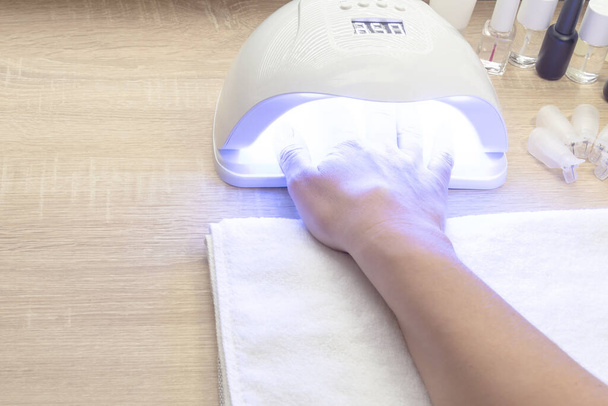 Procedimiento de manicura de uñas en gel - Neils de secado de mujer en lámpara Led-UV. Copiar espacio para texto - Foto, Imagen