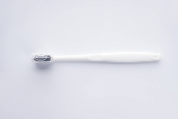 Cepillo de dientes blanco con cerdas negras sobre fondo blanco. Acostado. Aislado
 - Foto, Imagen