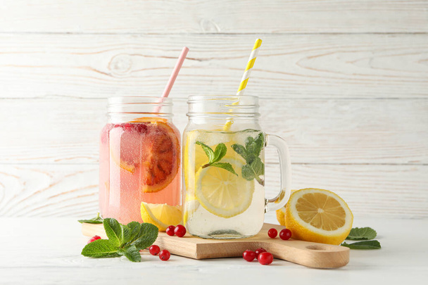 Glass jars with lemonade on wooden background. Fresh drink - Photo, Image