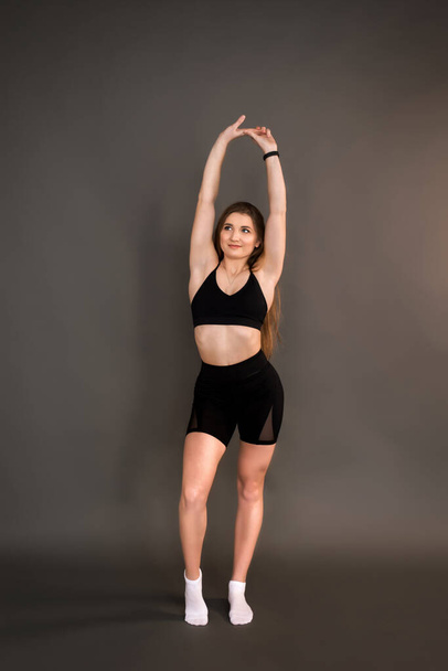 Fitness girl on a dark background. - Valokuva, kuva