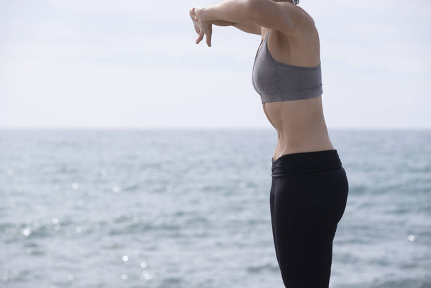 Nainen tekee hypopressiivinen liikunta meressä
 - Valokuva, kuva