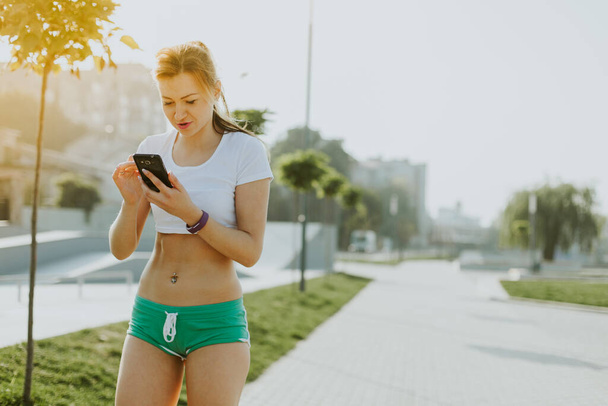 Fitness runner mulher falando no smartphone na natureza
. - Foto, Imagem