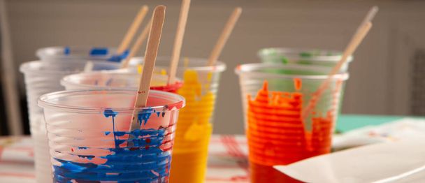 Colores acrílicos del artista en vasos de plástico en el estudio de arte
 - Foto, imagen