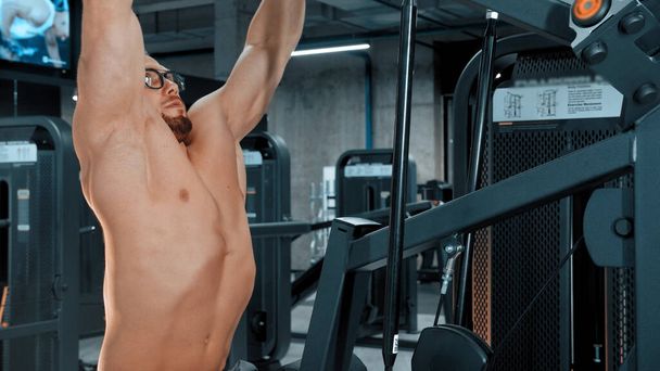 Ein attraktiver Mann Bodybuilder macht Kraftübungen in der Sporthalle - Foto, Bild