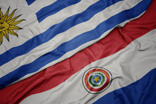 Színes paraguay zászlót lobogtatva és nemzeti uruguay zászlót lobogtatva. makroszintű - Fotó, kép