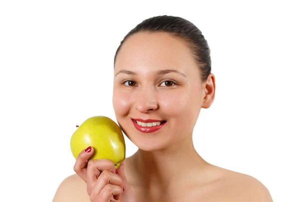 Young beautiful smiling woman touches the apple to face - isolated on white. - Foto, Imagem